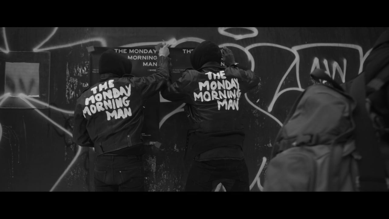 Black-and-white film frame of the Monday Morning Man street campaign.
