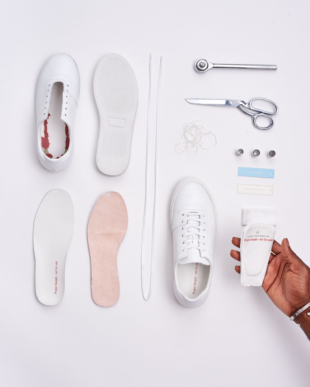 The sneaker’s upper, sole, insole, laces and tools laid out for a construction study.