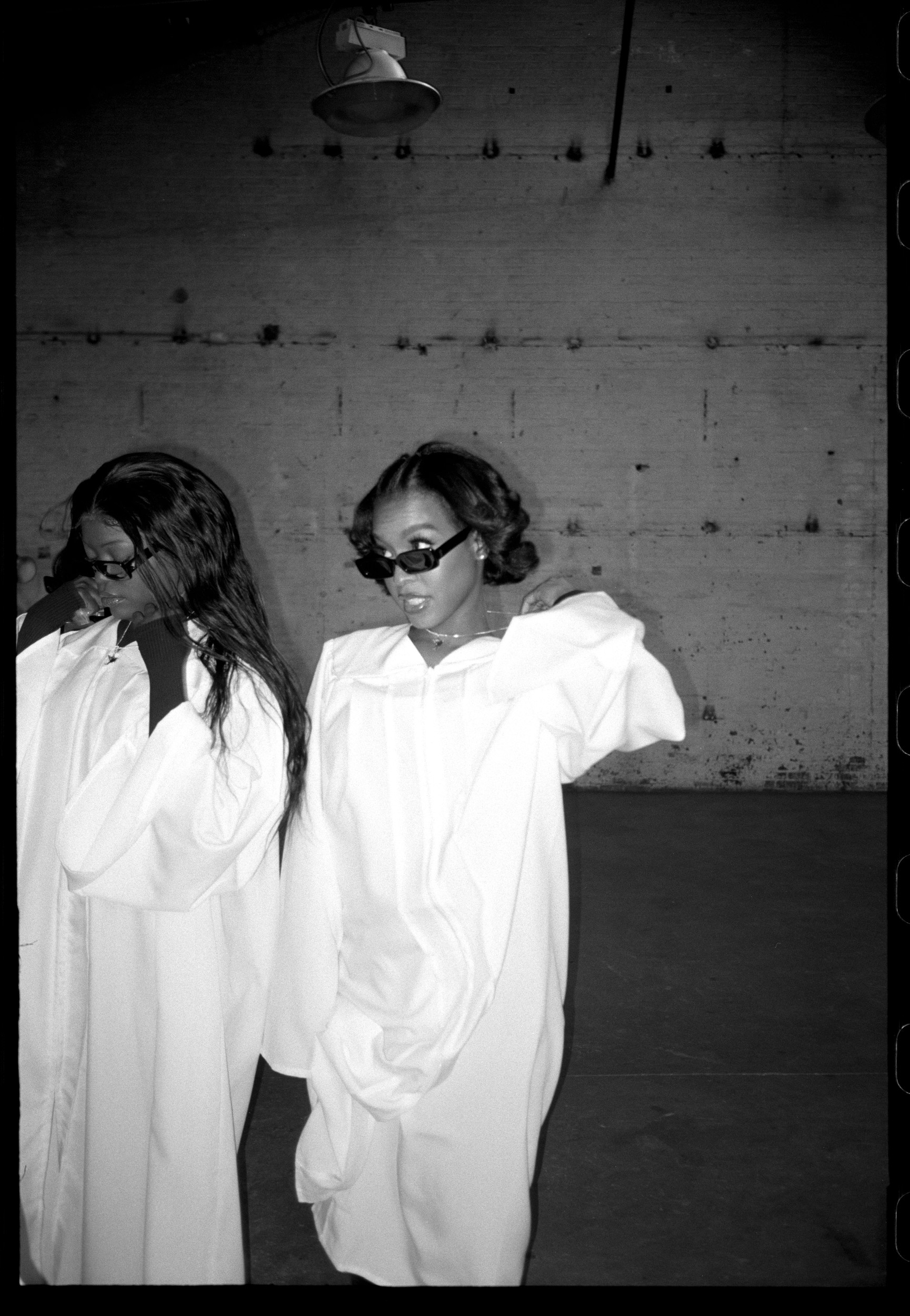 Two members of the New York City Gospel Choir in white robes.