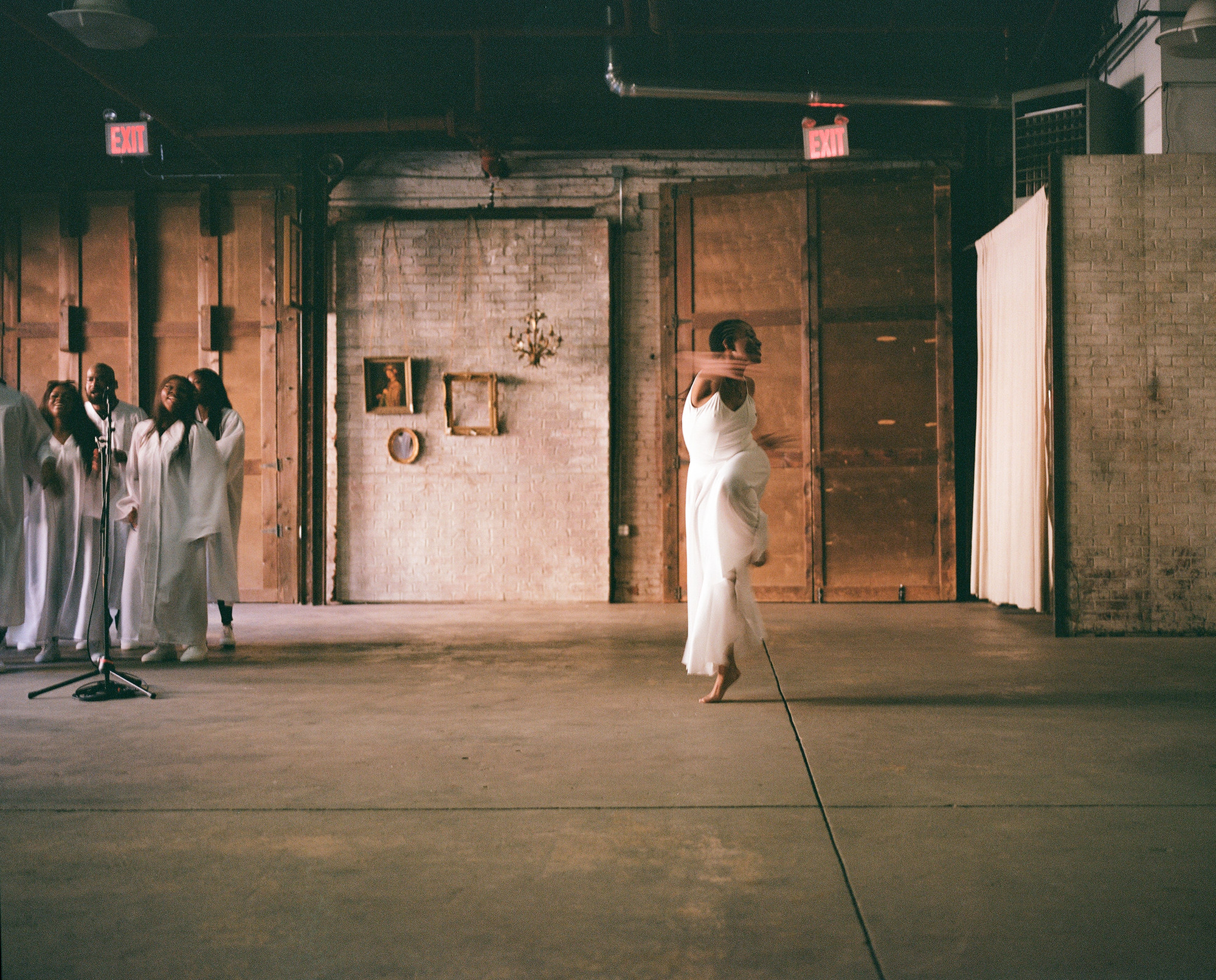 Deja Robinson dances in the studio while the choir stands at the side.