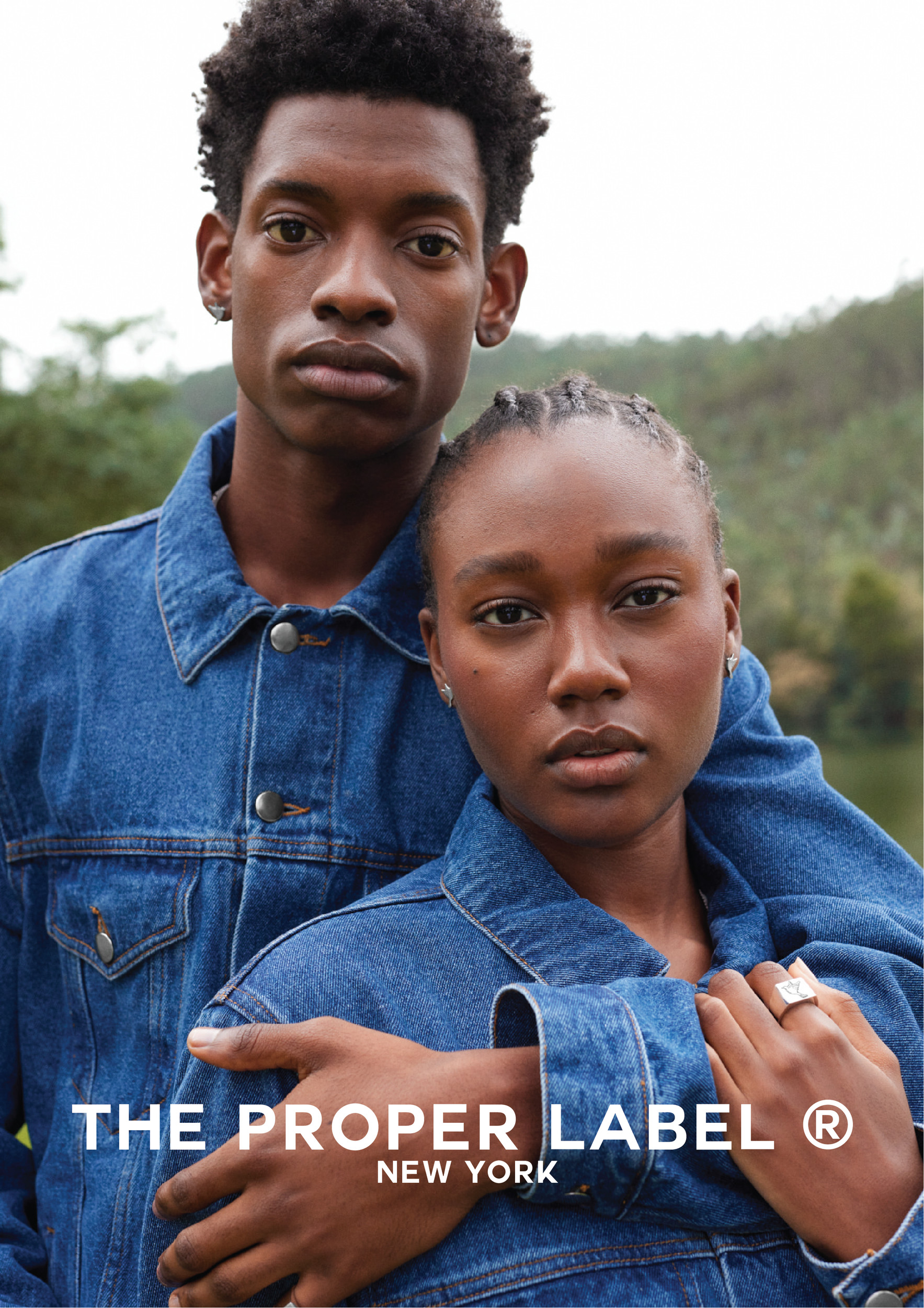 Two models in blue denim beside a lake.